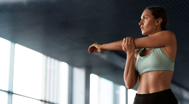 Mujer calentando antes de sesión con entrenador personal para perder peso