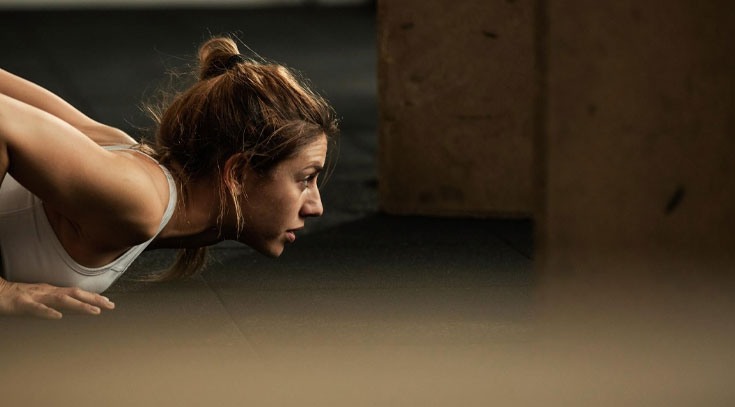 Mujer realizando flexiones durante sesión con entrenador personal para perder peso