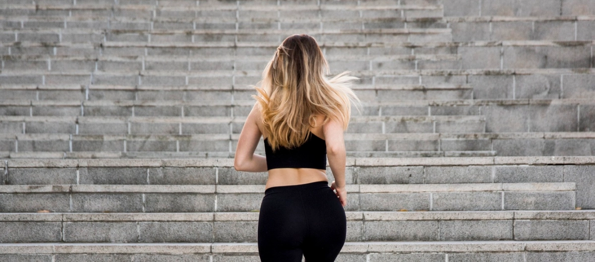 Mujer de más de 40 años subiendo escaleras, ejemplo de fuerza funcional frente a la pérdida muscular